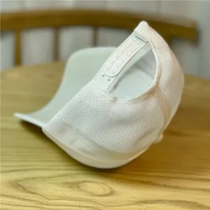 Detalle de gorra trucker blanca con malla transpirable y cierre snapback ajustable