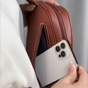 Detail of the back zipper pocket on a brown leather chest bag fitting a smartphone