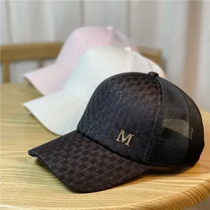 Gorra de béisbol de malla a cuadros con logotipo M metálico en negro, blanco y rosa.