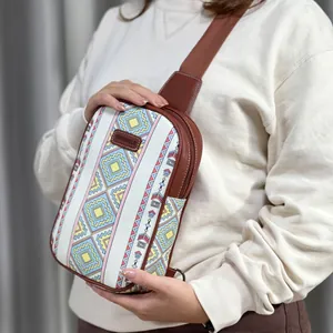 Fashionable canvas sling bag with colorful geometric pattern and brown leather trim