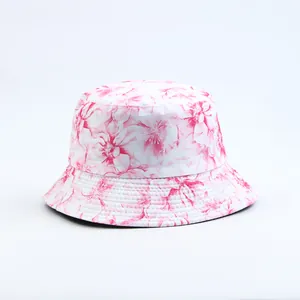 Close-up detail of white bucket hat featuring a vibrant pink floral pattern print