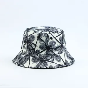 Close-up of stylish bucket hat with black palm tree print on white fabric.