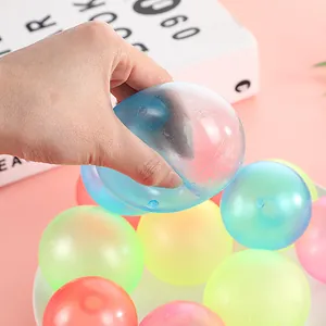 Detail eines durchsichtigen leuchtenden Klebeballs, der zur Entspannung gedrückt wird.
