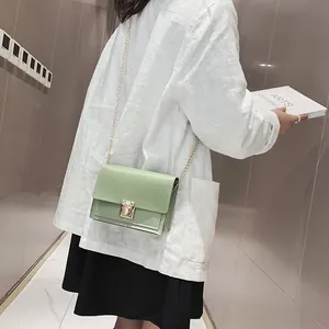 Light green minimalist square crossbody bag with elegant gold chain strap on model