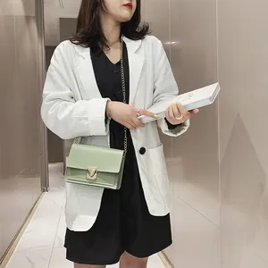 Detailed lifestyle shot of a light green small square chain crossbody bag worn by model.