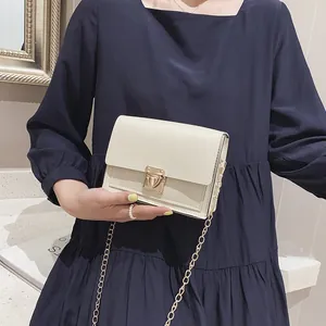 Small off-white square bag with elegant gold latch and chain strap detail