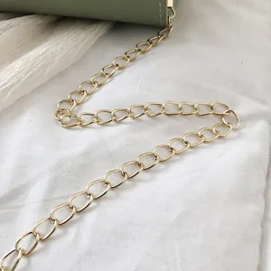 Detailed macro view showing the high-quality gold metal chain strap of a green bag