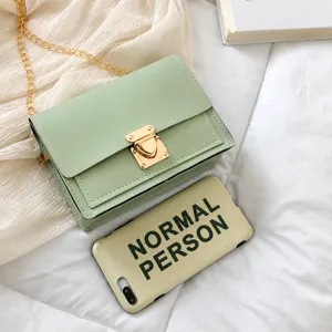 Pequeño bolso bandolera cuadrado verde menta comparación de tamaño con un móvil