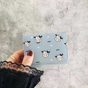 Close-up of mini three-fold wallet with cute cow pattern in light blue finish