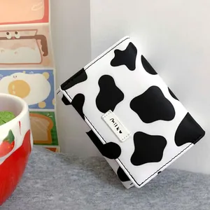 Close-up view of a stylish trifold black and white cow print mini wallet for women