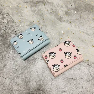 Cute three-fold mini wallets with charming cartoon cow and strawberry patterns in blue and pink.