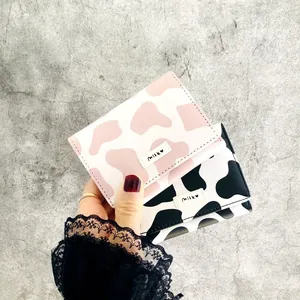 Detailed macro view of pink and black cow print tri-fold mini wallets