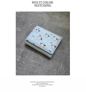 Detailed view of light blue tri-fold women's wallet featuring cute cartoon cow pattern