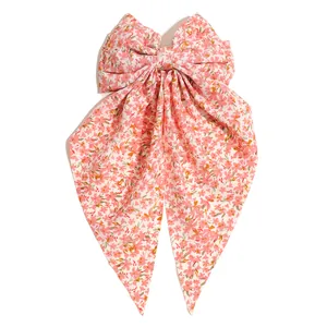 Detail showing the pink floral fabric and streamer tails of the large hair bow clip