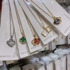Close-up detail showing multiple colors of titanium steel four-leaf clover pendant necklaces
