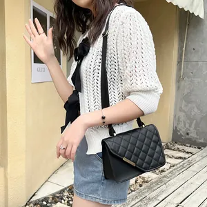 Modische schwarze Stepptasche mit Gurtband und goldenem Akzent