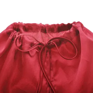 Detalle del cuello con cordón ajustable en una capa de superhéroe de satén rojo para niños