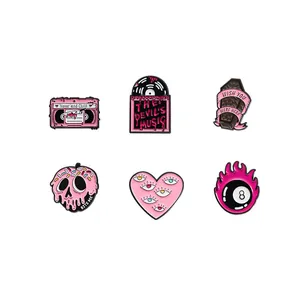 Set of six pink and black goth enamel pins featuring skull, heart and music themes