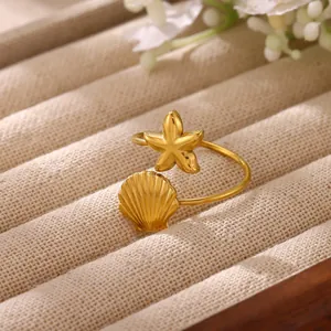 Primo piano di un anello regolabile dorato con delicati motivi a stella marina e conchiglia