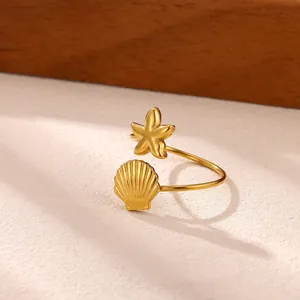Dettaglio di un anello regolabile dorato a tema marino con conchiglia e stella marina