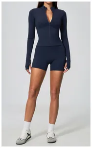 Close-up of navy blue long sleeve yoga top and high waist sports shorts on model.