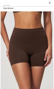 Detail of high-waisted dark brown yoga shorts on model, showing soft fabric and fit