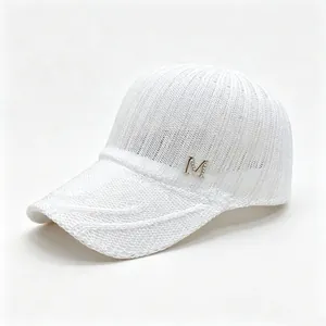Detailed view of white knitted breathable mesh baseball cap with crystal M logo