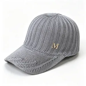 Close-up detail of breathable grey knitted mesh baseball cap with metallic M logo