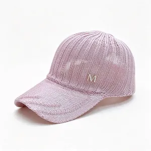 Close-up view of pink knitted breathable mesh baseball cap with silver M logo embellishment