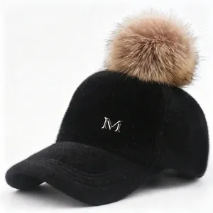 Vista detallada de una gorra de béisbol negra con un pompón grande de piel marrón