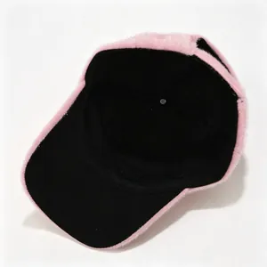 Vista detallada que muestra el suave forro interior negro de una gorra de béisbol rosa.