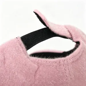 Vista detallada de una gorra de béisbol rosa peluda con cierre de velcro ajustable atrás.