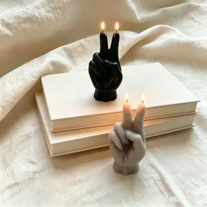 Vista dettagliata di candele profumate gesto mano vittoria in nero e grigio