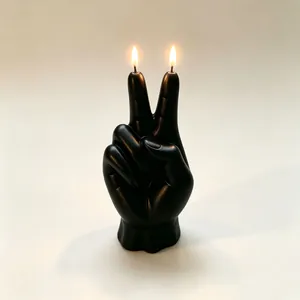 Dettaglio di una candela profumata nera a forma di mano della vittoria accesa