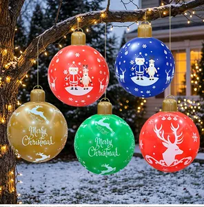 Detailed view of large inflatable Christmas balls hanging in a snowy outdoor garden