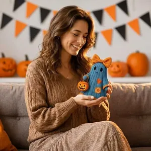 Vue détaillée d'une mignonne figurine de fantôme d'Halloween bleue au crochet dans les mains