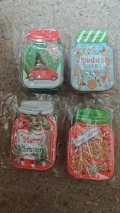Detailed view of four festive Christmas-themed jar-shaped tin candy boxes in plastic wrap