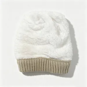 Gros plan sur la texture pelucheuse blanche du bonnet d'hiver avec revers côtelé beige