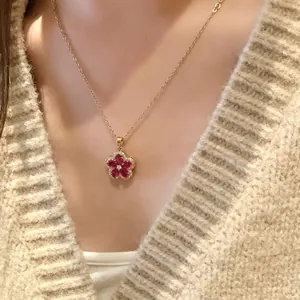Vista dettagliata di un'elegante collana con ciondolo a fiore rosso e catena d'oro