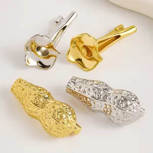 Dettaglio di quattro spille artistiche in oro e argento a forma di calla e arachide.