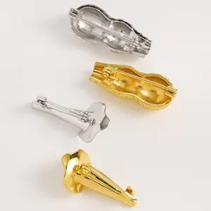 Dettaglio del meccanismo a spilla sul retro delle spille color oro e argento.