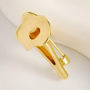 Dettaglio di una spilla minimalista a giglio di calla dorata per abiti artistici
