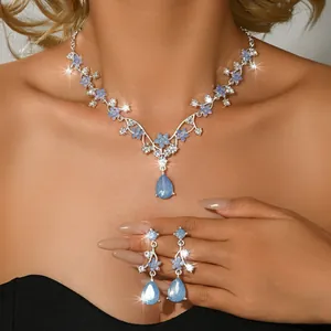 Detailed close-up view of vintage blue floral necklace and drop earrings set on model