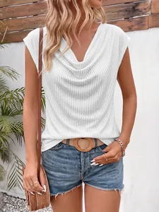 Détail d'un t-shirt blanc à col bénitier orné de strass brillants et étincelants.
