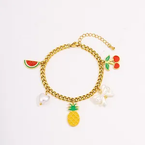 Close-up of a gold stainless steel link bracelet featuring various fruit and bow charms