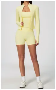 Detailed view of women's yellow three-piece yoga set with zip-up jacket and sports shorts