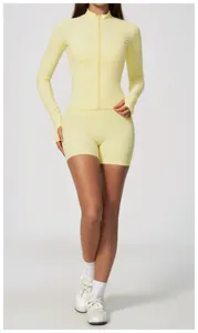 Detail view of women's pale yellow zip-up slim fit yoga jacket and shorts