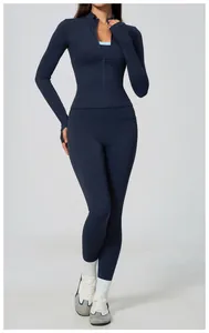 Full-body view of woman in navy blue zip-up sports jacket and matching yoga leggings