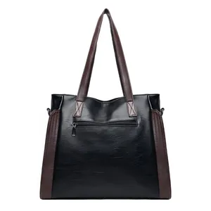 Back view of a black soft leather tote bag with a zipper pocket and brown straps