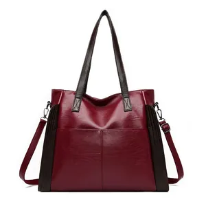 Front view of a stylish burgundy soft leather tote bag featuring dark brown handles and straps